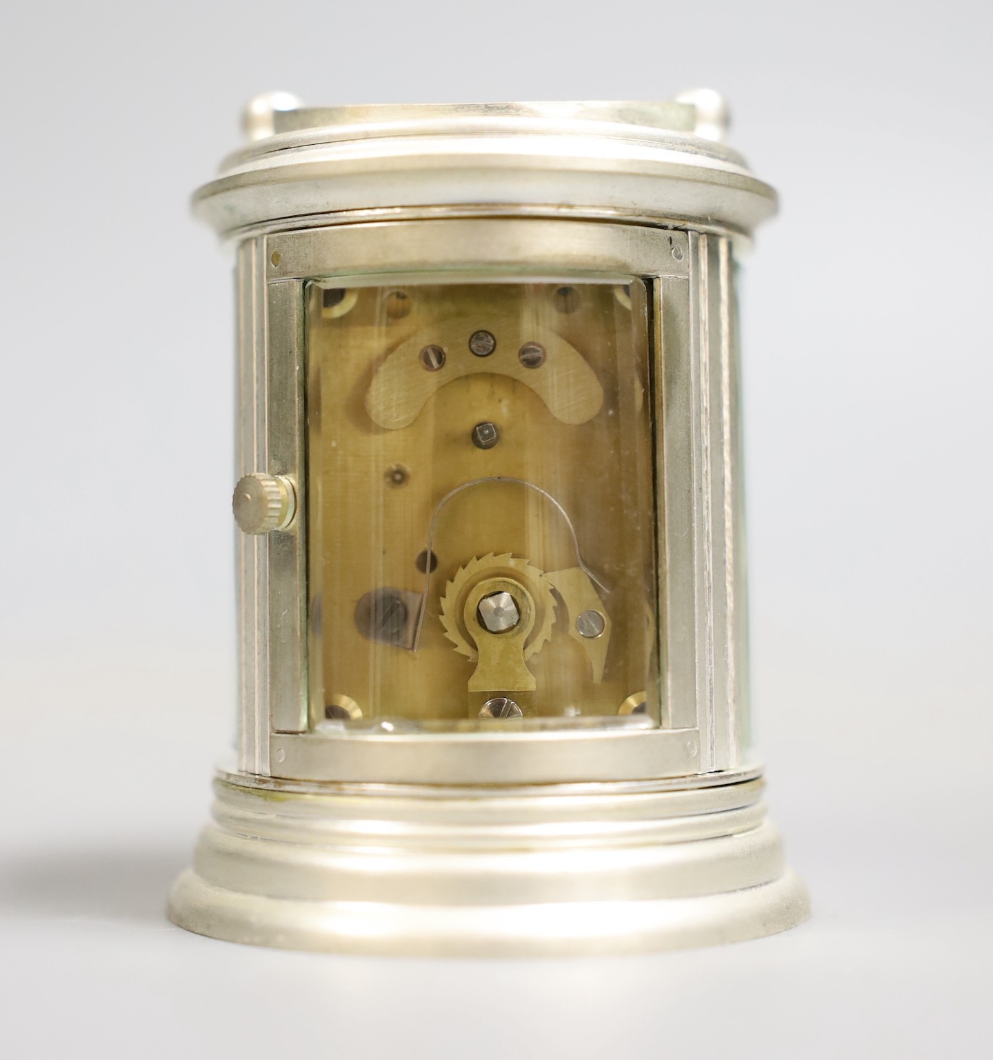 A circular plated carriage clock with key and a Victoria Cross gent's wristwatch